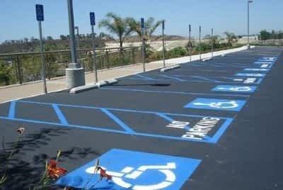 Row of disability parking spaces with hatch marks and signs